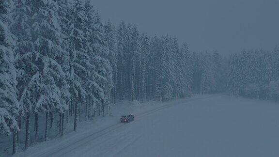 空中汽车行驶在积雪覆盖的森林道路上