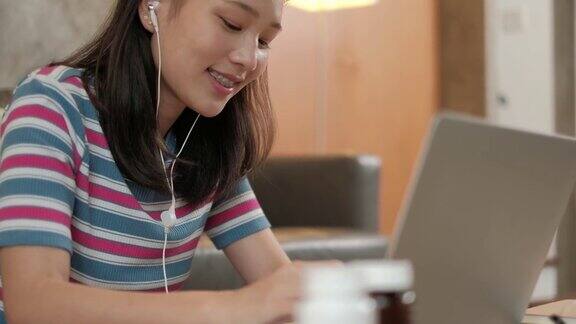 亚洲妇女使用笔记本电脑在家工作和在线学习