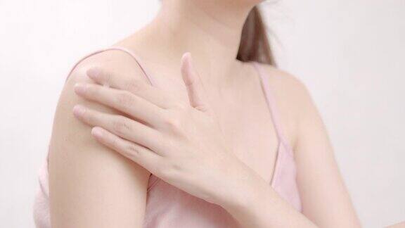 亚洲成年女性用手在肩膀上涂抹保湿霜身体保健