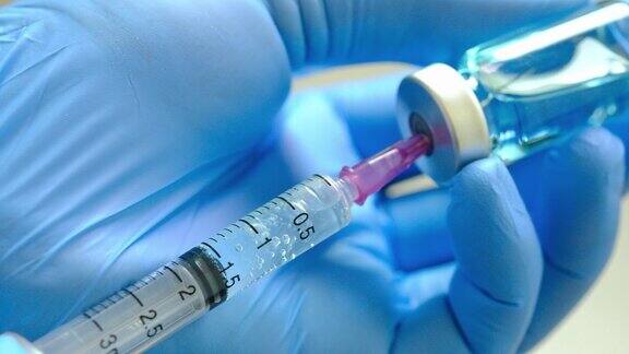 医院里医生手里拿着注射器和蓝色的疫苗瓶健康和医学概念