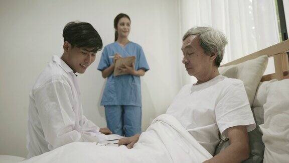 医生和护理护士在家里的床上检查亚洲老年男性健康的场景家庭保健