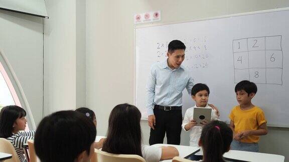 亚洲小男孩建议一起思考数学答案的方法老师在学校的教室里教孩子们教育理念、经验学习和技能发展