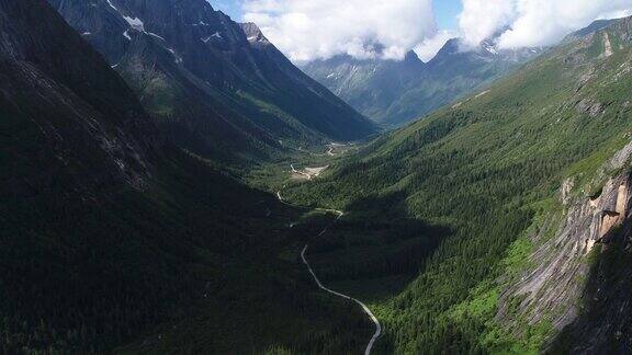 无人机在峡谷里飞着雪山和松林