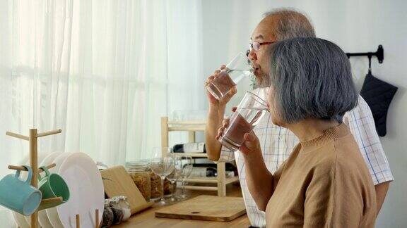 为了放松和保健亚洲老人相视而笑喝着水