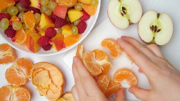 准备水果沙拉用水果和浆果-剥皮的橘子