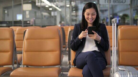 亚洲商务女性在机场用智能手机