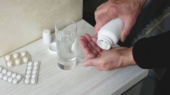 一位老人用一杯水喝了一剂药处方治疗一个手里拿着药片的老人