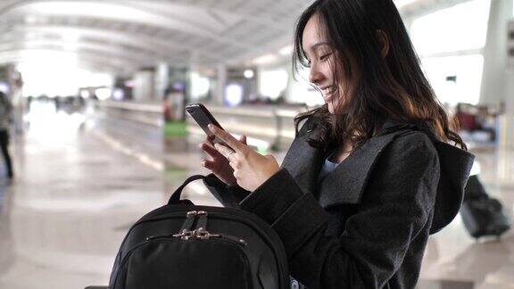 年轻女子在机场使用智能手机