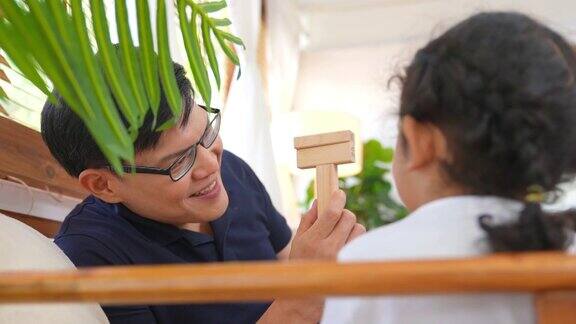 4K亚洲父亲和小女儿在家里玩木制玩具