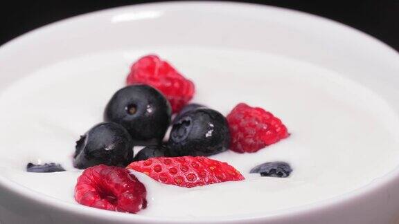 俯视图草莓覆盆子蓝莓落在牛奶上