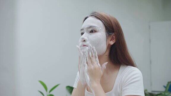 亚洲妇女用泡沫霜和肥皂洗脸清洁皮肤