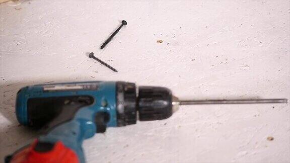 工人用电动螺丝刀将木板固定在墙上