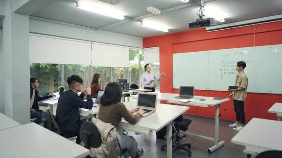 一名亚裔华裔大学生在白板上写下答案向课堂上的同学和讲师讲解