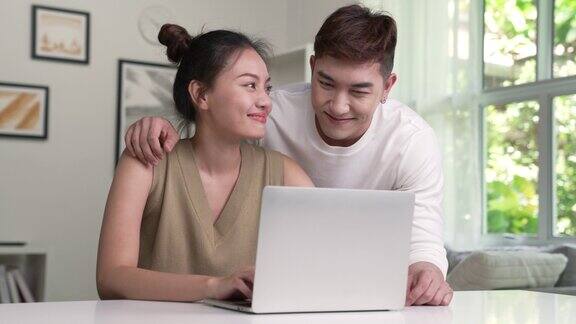 年轻的亚洲夫妇使用笔记本电脑年轻夫妇爱的时刻幸福观念
