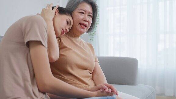 亚洲慈爱的年迈母亲安慰因问题而哭闹的女儿关心年长的母亲支持安慰和理解同情年轻女性的压力在家里的眼泪家庭关系