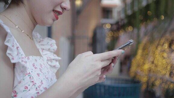 特写手的女人使用智能手机与阳光