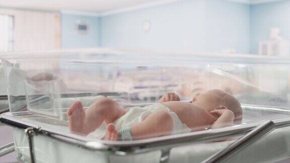 新生儿出生后躺在产科病房的摇篮里的肖像可爱的新生儿呼唤母亲感觉精力充沛失眠分娩和医疗诊所概念