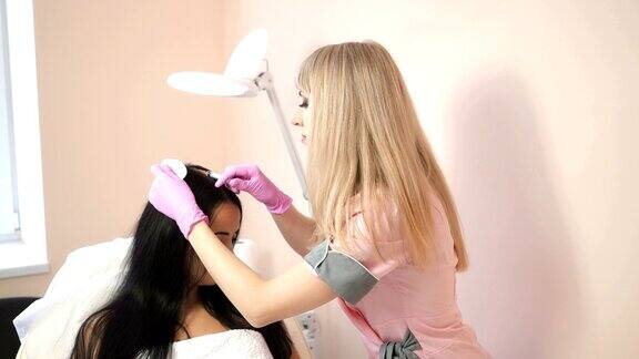 女性美容师在头皮上注射维生素和矿物质
