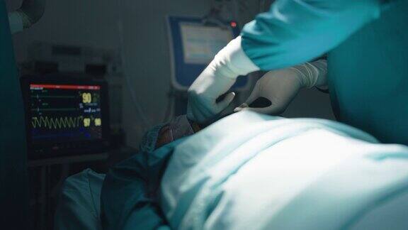 外科医生和护士帮助重症监护病人进行心肺复苏使用除颤器电击心脏以挽救病人的生命卫生保健