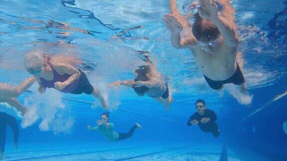 亚洲华人教练看着他们的高中学生在游泳池里游泳