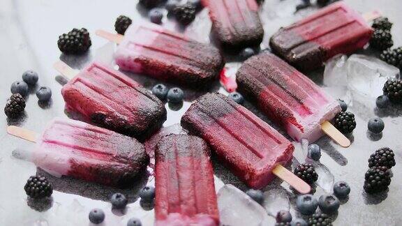 自制黑莓和奶油冰淇淋或冰棒与冷冻浆果在黑色板岩托盘
