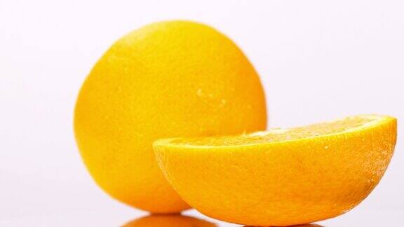 橙子被切成两半放在旋转的白色桌子上
