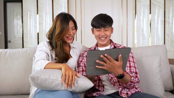 幸福的年轻夫妇用平板电脑和朋友聊天