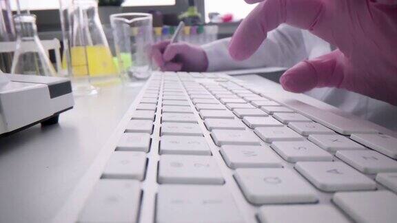 科学家实验室进行研究键入键盘并记录数据