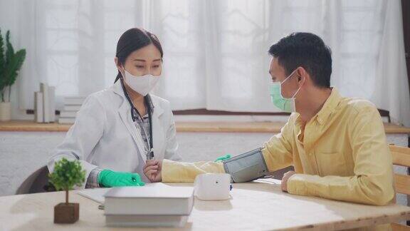 女医生用血压与年轻亚洲男子病人在家访