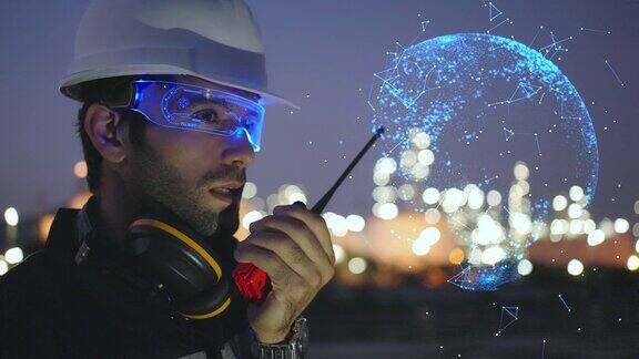 白种人或中东工程师戴着高科技人工智能眼镜或虚拟现实眼镜使用对讲机检查炼油厂的状况动态图形世界连接通信概念