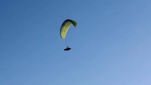 在太阳和美丽的云彩的背景飞行滑翔伞夏天的一天