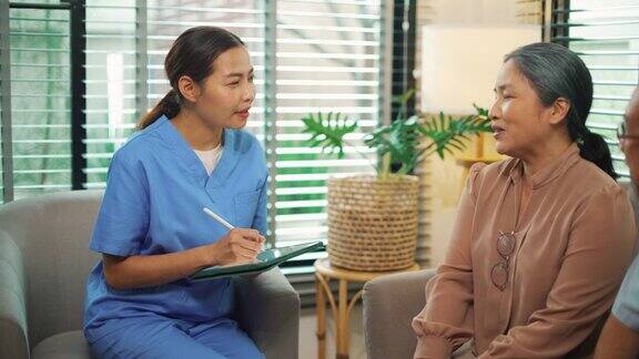 亚洲女护士与老人交谈并测量血压