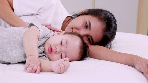 妈妈和宝宝一起睡午觉母亲和婴儿白天睡在床上