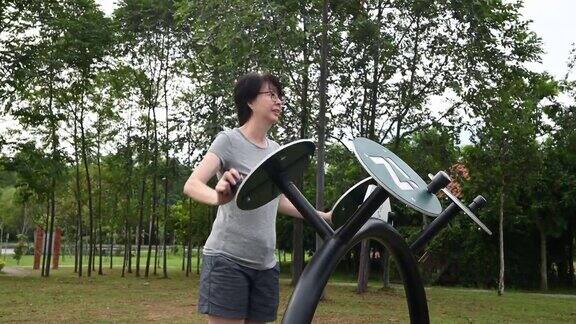 成熟的亚洲女人在公园里做伸展运动
