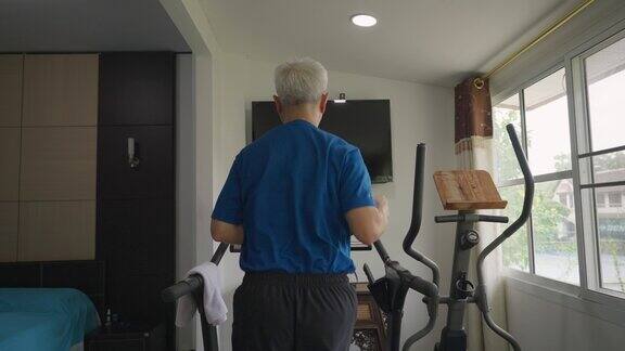 亚洲中年男子在跑步机上跑步在家锻炼身体保持身体健康