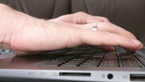 男性用手在笔记本电脑键盘上打字