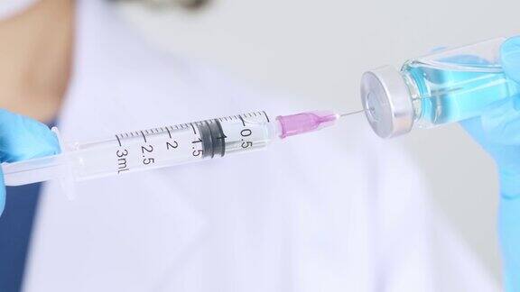 医院里医生手里拿着注射器和蓝色疫苗瓶健康和医学概念