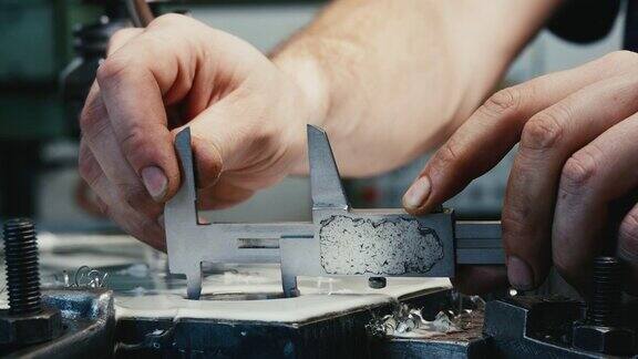 工厂里的工人用游标卡尺测量钢孔