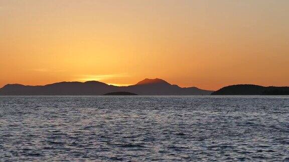 希腊伊古门尼察海岸山间美丽的金色落日