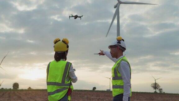 工程师工作与无人机检查风力涡轮机农场绿色能源