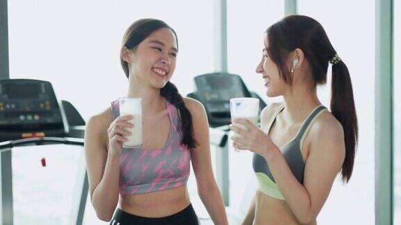 迷人的健美亚洲女人完成锻炼和喝蛋白质牛奶奶昔维生素训练后健身健康的生活方式