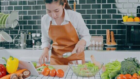 一名素食妇女在厨房做饭时用碗搅拌蔬菜沙拉