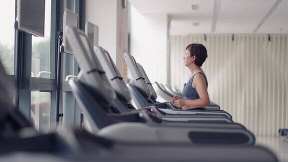 女性在跑步机上跑步新常态与现代健身房