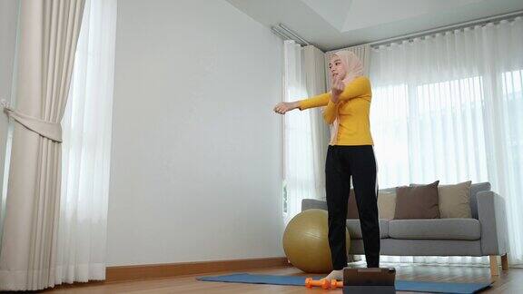 年轻的穆斯林亚洲妇女在家锻炼保健理念健身
