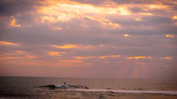 在一个神奇的日落中冲浪者在海洋中