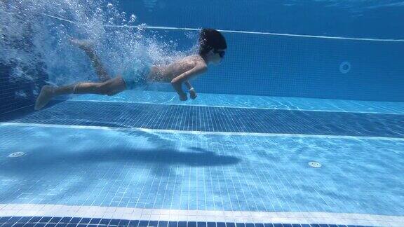 快乐的男孩跳进了游泳池