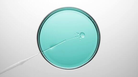 化学滴管将油注入培养皿中的青色液体中