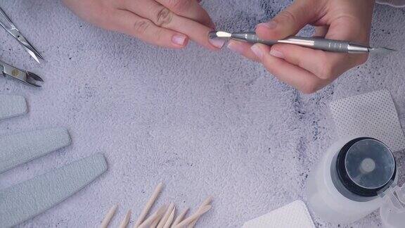女性的手在修指甲去除角质层指甲护理自我护理在家的时候自己修指甲Diy油漆锉和椭圆形指甲