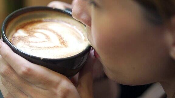 亚洲女商人在咖啡店喝拿铁咖啡的4K特写