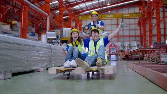 一群亚洲工人在工厂内的手推车上玩耍
